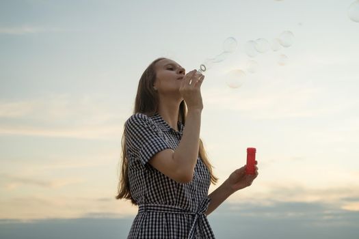 girl blowing soup bubbles, closeup, concept of fun and happiness