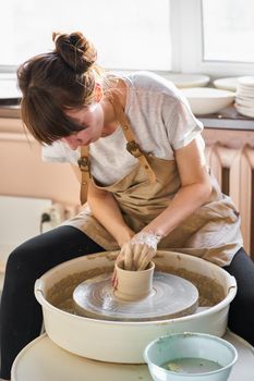 Woman making ceramic pottery on wheel, hands close-up. Concept for working woman in freelance, business, hobby