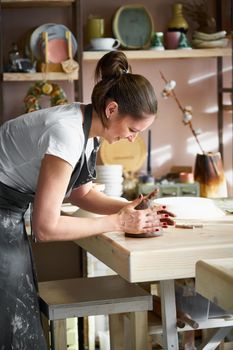 Woman freelance, business, hobby. Woman making ceramic pottery on table in studio