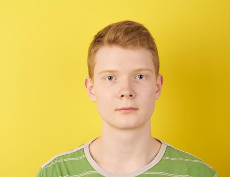 shaven teenager looks confident, wearing green t-shirt, ginger person portrait