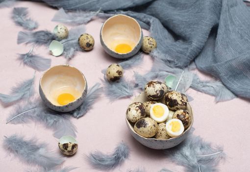 quail eggs in ceramic vases, gray feathers on the table, easter still life, natural food, diet and antioxidants, dark key and shallow depth of field. High quality photo