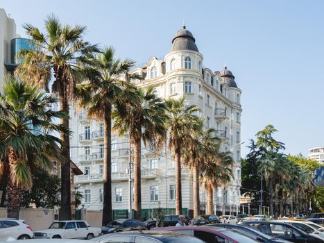 SOCHI, RUSSIA - May 27, 2021. Facade of apartment hotel Matisse. Beautiful building with palm trees alley at sunny day.