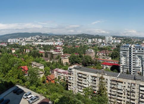 SOCHI, RUSSIA - May 27, 2021. Panorama view of central district of Sochi. Apartment buildings and mountains on horizon.