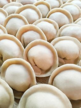 Full frame photo of meat pelmeni. Rows of handmade raw dumplings, traditional Russian food.