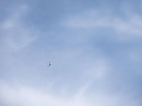 Airplane is flying in clear blue sky. Aircraft in flight in good weather. Minimalism.