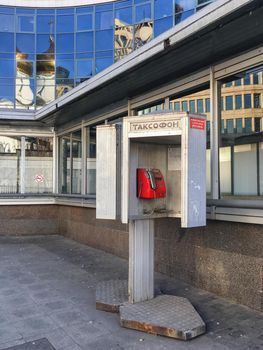 MOSCOW, RUSSIA - November 23, 2019. Old telephone booth on street. Urban public taxiphone with push buttons in small open booth.