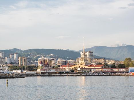 SOCHI, RUSSIA - May 03, 2021. Port of Sochi, sea embankment and residential district at sunset. View from Black sea in sunny weather.