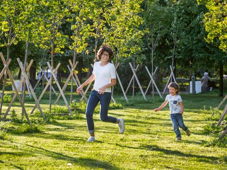 Family life. Mother and son play in park. Summer vibes. Active outdoor game. Lifestyle. Leisure activity open air.