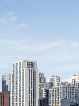 New residential district of Moscow. Modern architecture of apartment buildings. Vertical banner with clear blue sky. Russia.