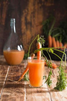 freshly squeezed carrot juice, and raw carrots, vegetarian vegetable vitamin drink, vintage still life concept, fresh carrot juice on wooden background, rustic still life