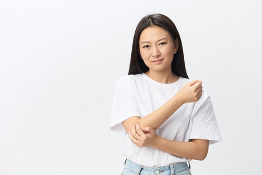 Tormented suffering tanned beautiful young Asian woman hurting holding painful elbow posing isolated on white background. Injuries Poor health Illness concept. Cool offer Banner