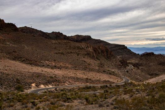 Curved road in a mountain under a cloudy sky in Arizona