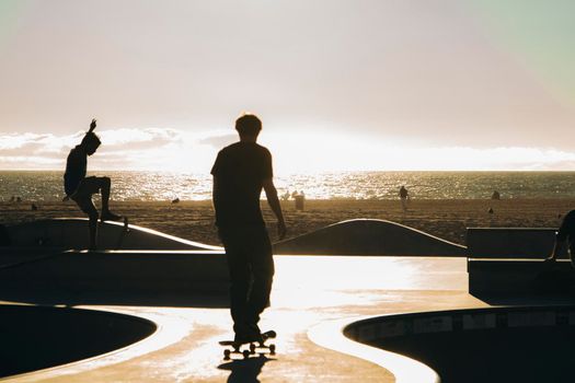 Skaters in the evening in backlight in Venic e Beach in Los Angeles