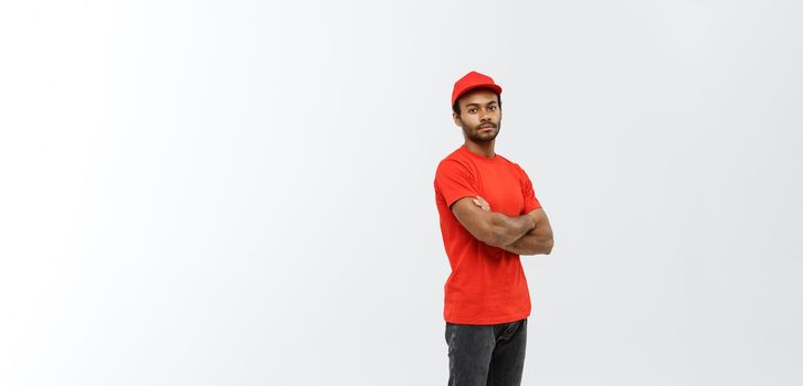 Delivery Concept - Handsome African American delivery man crossed arms over isolated on Grey studio Background. Copy Space