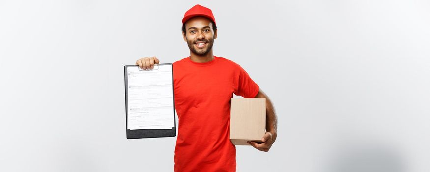 Delivery Concept - Portrait of Handsome African American delivery man or courier showing a confirmation document form to sign. Isolated on Grey studio Background. Copy Space