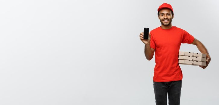 Delivery Concept - Portrait of Handsome African American delivery man or courier with pizza box showing mobile phone on you to check the order. Isolated on Grey studio Background. Copy Space