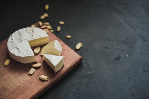 cheese camembert with mold and nuts on the wooden cutting board