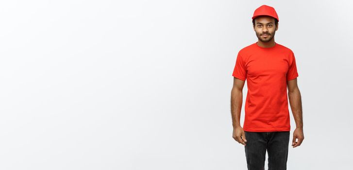 Delivery Concept - Handsome African American delivery man. Isolated on Grey studio Background. Copy Space