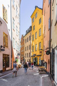 STOCKHOLM, SWEDEN - July 06, 2017. Tourists walk on narrow streets in historic part of town. Old fashioned buildings in Gamla stan.