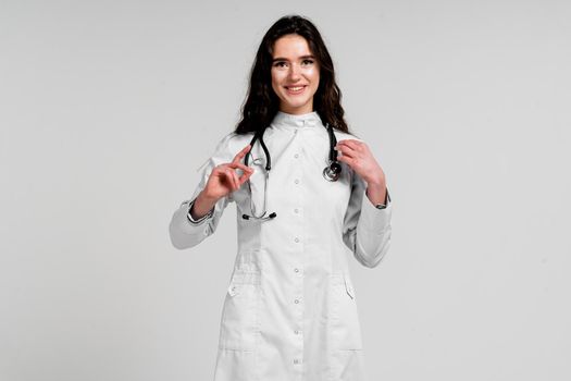 Doctor in medical robe with stethoscope at coronavirus covid-19 period. Nurse in white medical dress on white background
