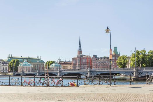 STOCKHOLM, SWEDEN - July 06, 2017. Bicycles parked on embankment. View on Norstedtshuset or Norstedt Building and Riddarholmskyrkan or Riddarholmen Church.