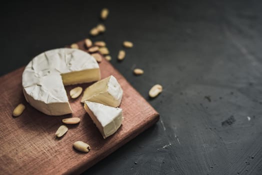 cheese camembert with mold and nuts on the wooden cutting board