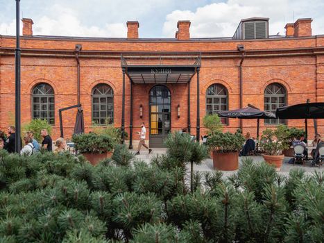 SAINT-PETERSBURG, RUSSIA - August 15, 2021. Tourists eat in Kuznya - renovated old building. New Holland - modern recreation park in historic center of town.