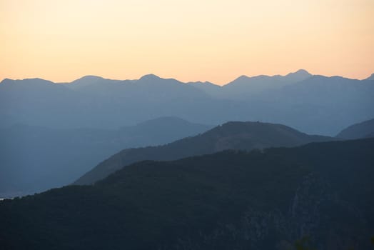 Sunset mountain range silhouette in golden hour.
