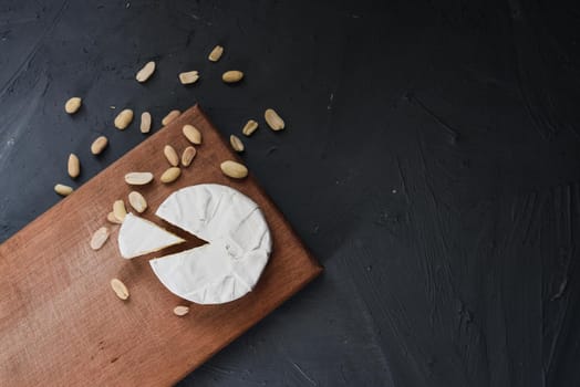 cheese camembert with mold and nuts on the wooden cutting board