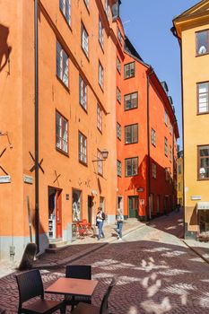 STOCKHOLM, SWEDEN - July 06, 2017. Tourists walk on narrow streets in historic part of town. Old fashioned buildings in Gamla stan.