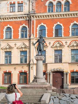 VYBORG, RUSSIA - August 16, 2021. Tourist takes photo of statue of Torkel Knutsson, Lord High Constable of Sweden, founder of Vyborg.
