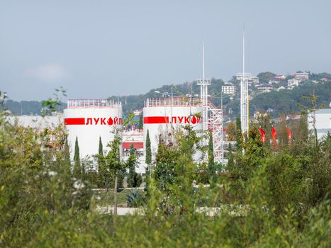 SOCHI, RUSSIA - October 11, 2018. Petroleum storage depot of Lukoil company. White buildings and red flags of of oil base.