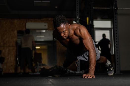 African american man doing one arm push ups in the gym