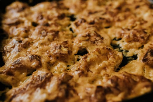 Meat cheese pizza. Baked meat in the oven lies on a black metal baking sheet. mouth-watering cheese sauce.