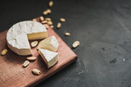 cheese camembert with mold and nuts on the wooden cutting board