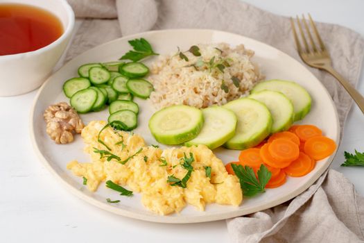 clean eating brown rice with zucchini and scramble with carrot and parsley, top view closeup