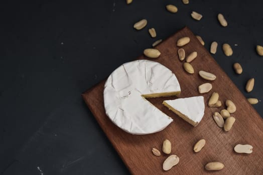 cheese camembert with mold and nuts on the wooden cutting board