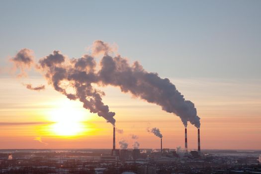 Tubes with smoke at winter sunset in Russia