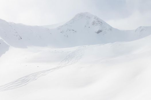 winter landscape, snow-capped mountains, the Caucasian ridge and traces from skiers and snowboarders