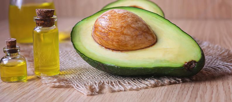 Avocado and avocado oil on wooden background. Selective focus.food