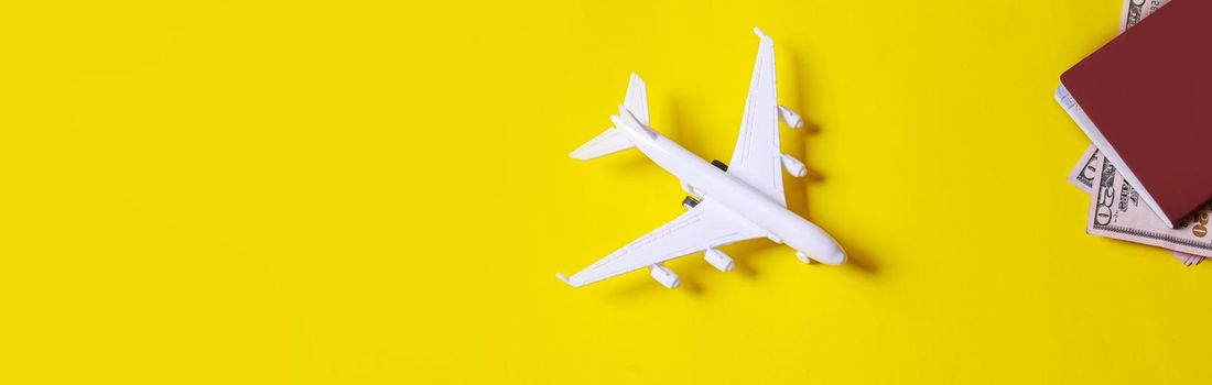 Travel preparation concept of airplane, money, passport, on yellow background. Selective focus.holidays