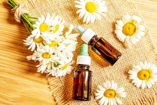 Chamomile essential oil in a small bottle. Selective focus.