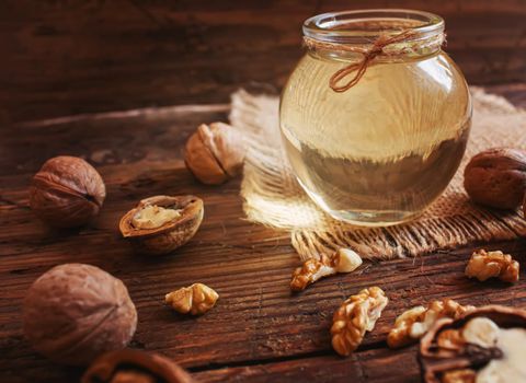 Walnut oil with nuts on a wooden background.selectiv focus.food