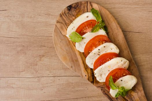 overhead view italian caprese salad with slices mozzarella cheese basil tomatoes serving board