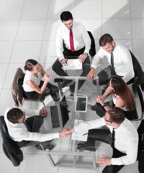 Office workers gather around a table to do research and implement new ideas.