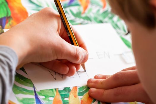 Kid writing on paper - Homework during the Covid 19 pandemic.