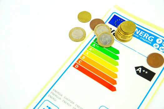 European Union Energy Label next to coins on white background