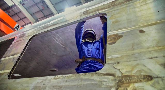 Workshop for assembling metal frames for subway cars, trams and trains. Welders assemble body parts.