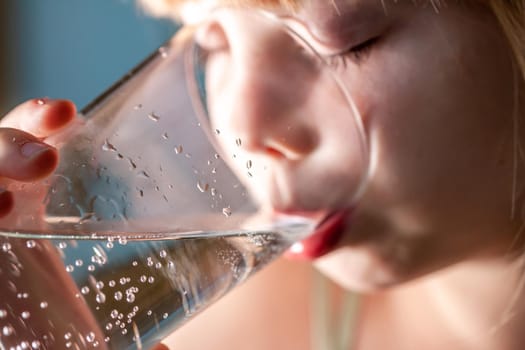 Little girl drinking a fresh glass of water.