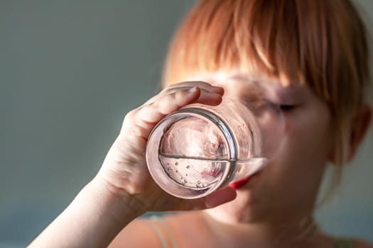 Little girl drinking a fresh glass of water.